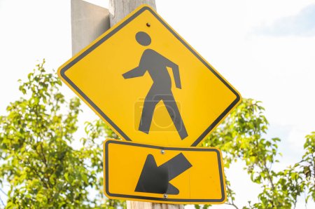 Photo for Vibrant yellow sign with a silhouette of children and pedestrians, symbolizing caution, safety, and the importance of protecting young lives on the street - Royalty Free Image