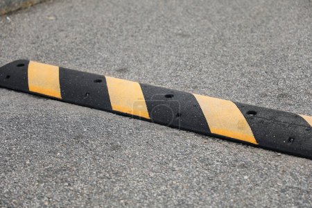 Photo for A symbolic barrier on the road, the street speed bump represents caution, safety, and the need to slow down in our fast-paced lives - Royalty Free Image