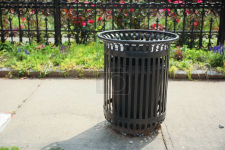 Foto de Un cubo de basura desechado se sienta en una calle estéril, simbolizando el desperdicio, el abandono y la urgencia de acciones ambientales responsables. - Imagen libre de derechos