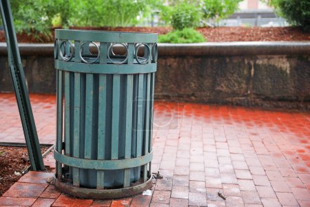 Foto de Un cubo de basura desechado se sienta en una calle estéril, simbolizando el desperdicio, el abandono y la urgencia de acciones ambientales responsables. - Imagen libre de derechos