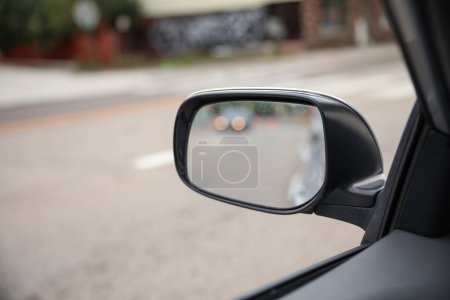 Téléchargez les photos : Miroir de voiture reflète l'introspection, la navigation et la perspective. Symbole de la conscience de soi, de la route à suivre et du voyage intérieur. Image conceptuelle - en image libre de droit