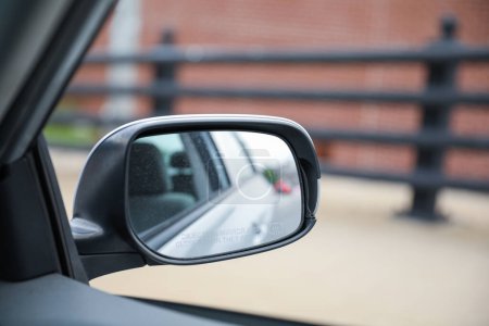 Téléchargez les photos : Miroir de voiture reflète l'introspection, la navigation et la perspective. Symbole de la conscience de soi, de la route à suivre et du voyage intérieur. Image conceptuelle - en image libre de droit