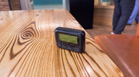 Photo for Pager beeper device rests on a desk, representing the power of instant communication, connectivity, and the evolution of technology - Royalty Free Image