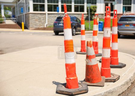 Photo for Bright orange construction cones arranged in a line, symbolizing safety, caution, and ongoing progress in construction and infrastructure projects. The cones represent temporary barriers - Royalty Free Image