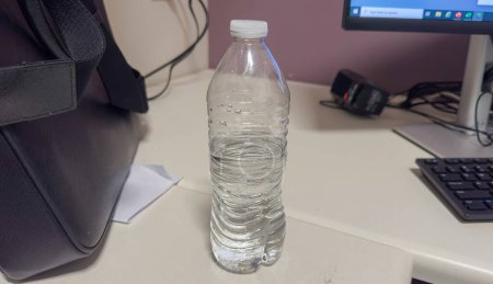 Foto de Agarrar firmemente una botella de agua de plástico, simbolizando el impacto ambiental y la urgencia de reducir los residuos de plástico de un solo uso - Imagen libre de derechos