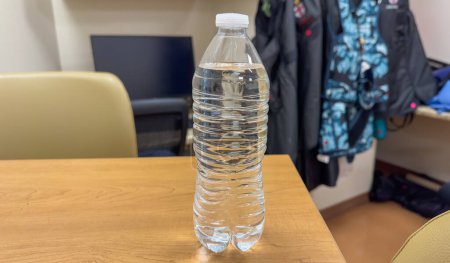 Photo for Hand tightly gripping a plastic water bottle, symbolizing the environmental impact and urgency to reduce single-use plastic waste - Royalty Free Image