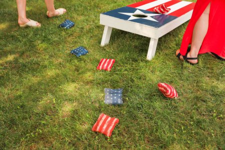 people playing cornhole, a popular American sport, representing camaraderie, outdoor leisure, competition, and the spirit of friendly gatherings