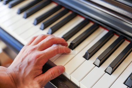 hands of a man playing piano.