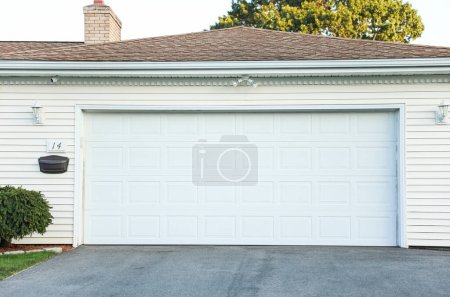 white garage with a door and a garage door