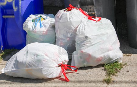 Téléchargez les photos : Collection de sacs à ordures colorés dans la rue. - en image libre de droit