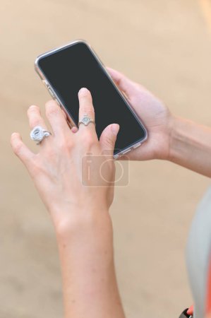 Photo for High angle view of anonymous woman hand holding and pointing with finger on empty smartphone during summer trip through nature in Mexico - Royalty Free Image