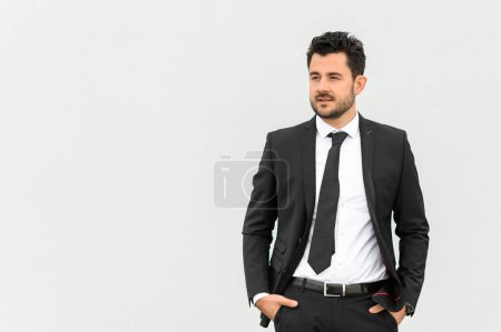 Téléchargez les photos : Entrepreneur masculin confiant en costume élégant regardant la caméra tout en se tenant debout sur fond blanc, contenu d'affaires. espace de copie - en image libre de droit