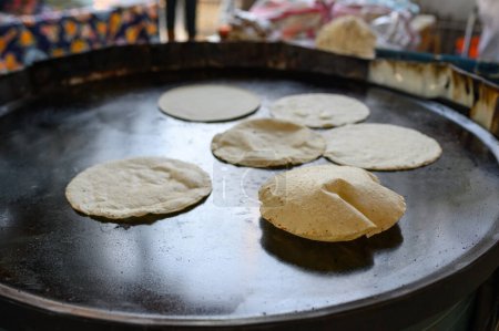 Photo for High angle of fresh dough placed on big metal baking pan on street in Mexico while preparing tasty chapati flatbread - Royalty Free Image