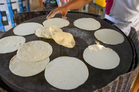 Photo for From above of crop anonymous cook preparing tortilla bread on griddle on street side restaurant - Royalty Free Image