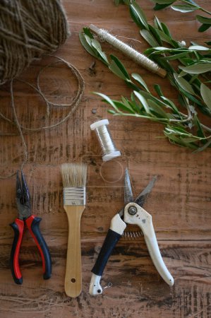 Photo for Top view of various tools and instruments placed with plants on wooden table at flower shop - Royalty Free Image