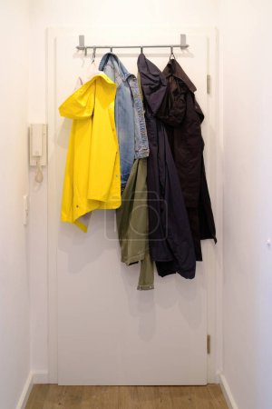 Photo for Stylish clothes hanging on rail near wardrobe in light room - Royalty Free Image
