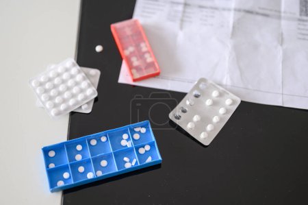 Foto de Vista superior de varias píldoras y medicamentos en la mesa en la caja del envase semanal - Imagen libre de derechos