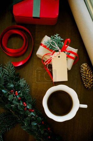 Foto de Vista superior de fondo de madera rústica con taza de café caliente y regalo de Navidad envuelto en papel. Fondo estacional disparado desde arriba. Piso laico, concepto de Navidad, burla de Navidad - Imagen libre de derechos