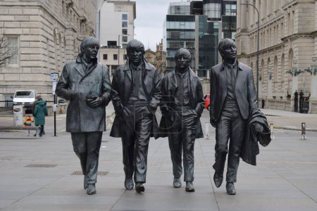 Téléchargez les photos : Liverpool, Merseyside, Royaume-Uni - 12 mars 2023 : Le bronze emblématique de Liverpool La statue des Beatles située à la jetée Devant les bâtiments classés des Trois Grâces. Attraction populaire Fab Four - en image libre de droit