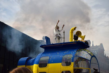 Téléchargez les photos : Liverpool, Merseyside, Royaume-Uni - 5 mai 2023 : Concours Eurovision de la chanson 2023, le Blue and Yellow Submarine Parade donne le coup d'envoi de la fête à Liverpool pour le lancement du hub des fans de l'EuroVillage. Homme dansant sur grand char de parade. - en image libre de droit