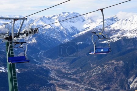 Téléchargez les photos : Télésiège vide pour skieurs et snowboardeurs surplombant la vallée de la Susa et le village alpin de Sauze D'Oulx, Piémont, Turin, Italie du Nord - en image libre de droit