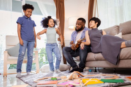Téléchargez les photos : Joyeuse danse familiale afro-américaine dans le salon, parfaite pour un projet axé sur la famille - en image libre de droit