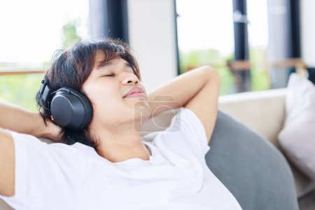 Photo for Relaxing at Home, Man Enjoying Music on a Comfortable Couch - Royalty Free Image
