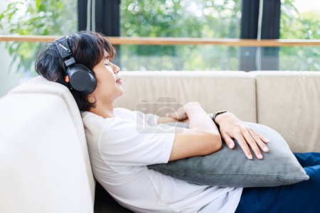 Téléchargez les photos : Loisirs, Homme À l'écoute de la musique et se détendre sur un canapé confortable - en image libre de droit