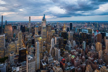 Foto de Un centro iluminado de la ciudad de Nueva York y nubes lluviosas encima. - Imagen libre de derechos