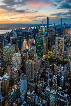 Téléchargez les photos : Un centre-ville illuminé de New York et des nuages pluvieux au coucher du soleil. - en image libre de droit
