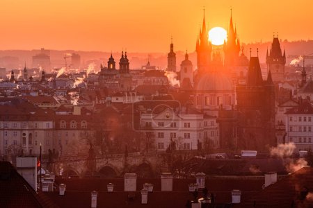 The rising sun in between towers of the Church of Our Lady before Tyn in Prague.