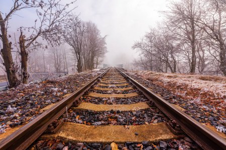 Railroad leading into the mist in a freezing day in winter in Krusne Hory, Czechia.