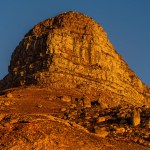 A famous rock Lion's Head in Cape Town during strong orange sunlight.
