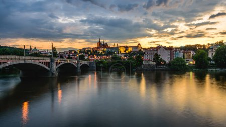 Foto de Castillo de Praga y Manesuv la mayoría (puente de Manes) sobre el río Moldava en Praga al atardecer. - Imagen libre de derechos