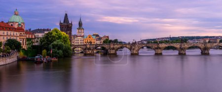 The Charles bridge over Vltava river in Prague during twilight.