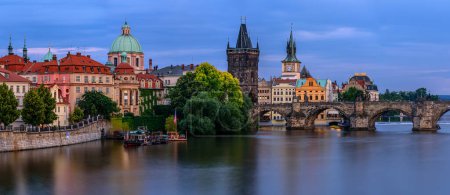 The Charles bridge over Vltava river in Prague during twilight.