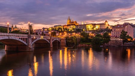 Foto de Castillo de Praga y Manesuv la mayoría (puente de Manes) sobre el río Moldava en Praga en el atardecer cielo rojo. - Imagen libre de derechos