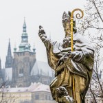 Statue of Saint Augustinus on Charles Bridge in Prague covered with snow. 