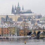 Prague castle and Charles bridge in the historical center of Prague covered in the first snow of the winter.