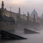 A mysterious autumn dawn at Charles Bridge covered in thick mist in historical center of Prague.
