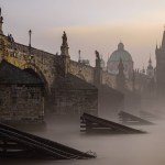 A mysterious autumn dawn at Charles Bridge covered in thick mist in historical center of Prague.
