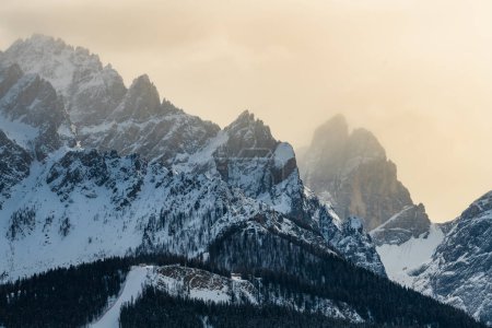 Peaks of Italian Dolomites in misty winter day.