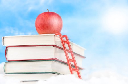 Foto de Escalera que llega a la manzana en la parte superior de la pila de libros en el cielo con el sol. Concepto educativo - Imagen libre de derechos