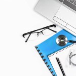Notepad with pen and glasses, stethoscope and laptop keyboard on white background, top view with copy space