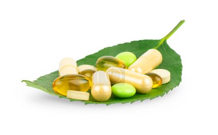 Foto de Vitamina, suplemento dietético y píldoras a base de hierbas en hoja verde aislado sobre fondo blanco, concepto de salud - Imagen libre de derechos