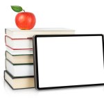 Digital tablet with blank display near the stack of books with apple on the top isolated on white background. Education concept