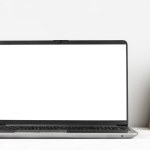 Laptop with blank display on white table, work place with copy space