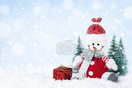 Foto de Muñeco de nieve con caja de regalo en el día nevado, tarjeta de felicitación de Navidad con espacio para copiar - Imagen libre de derechos