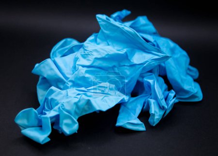 Photo for Blue crumpled medical latex gloves on a black background. - Royalty Free Image