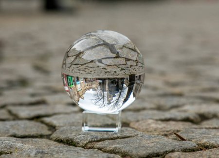 Téléchargez les photos : Image urbaine renversée de galets à travers une boule de verre photographique à la main humaine - en image libre de droit